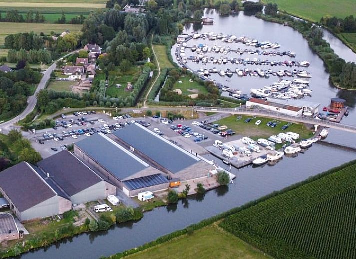 Cozy indoor area of Huisje in IJsselstein, vacation home located in Utrecht, with comfortable yellow armchairs and water views.