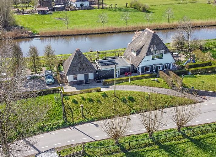 Luchtfoto van Vakantiehuisje in Hekendorp, Utrecht, met rieten daken en uitzicht op een rustige rivier en groene omgeving.