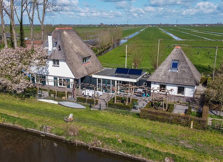 Luchtfoto van Vakantiehuisje in Hekendorp, Utrecht, met rieten daken en uitzicht op een rustige rivier en groene omgeving.