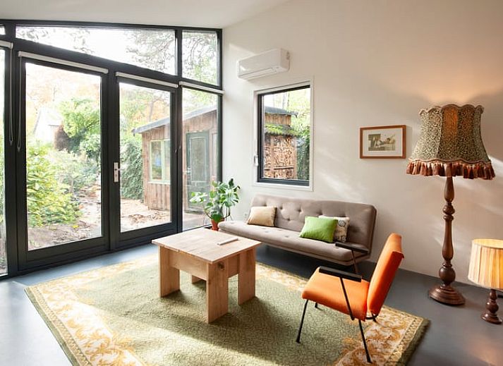 Vakantiehuisje in Bilthoven met moderne glazen gevel in Utrecht, omgeven door groen.