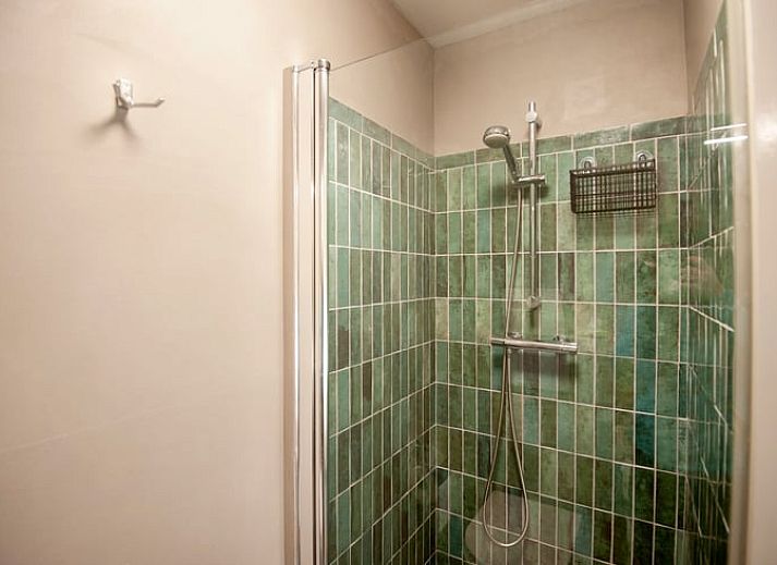 Schaduwrijke patio bij Vakantiehuisje in Bilthoven, Utrecht, met houten bank.