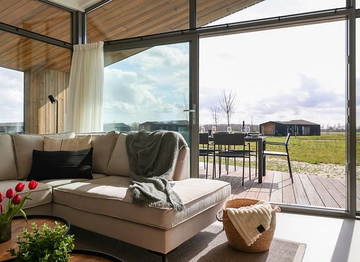 Die Aussenterrasse des Ferienhauses in Wissenkerke bietet einen Panoramablick auf die gruene Umgebung von Nord-Beveland, Zeeland.