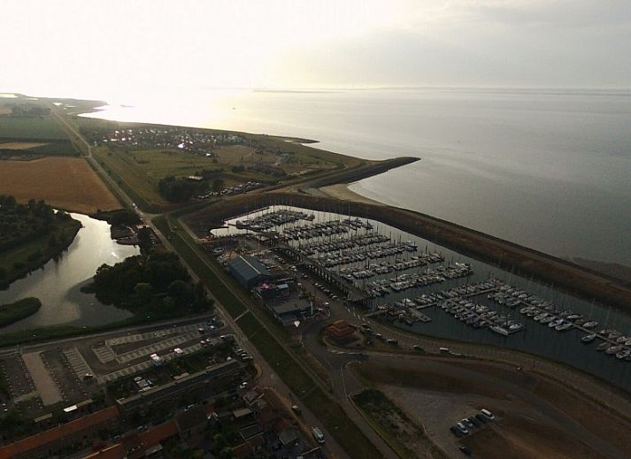 Gezellige binnenruimte van Inn d'n Eenhoorn in Colijnsplaat, Noord-Beveland, met comfortabele zitplaatsen en groene accenten.