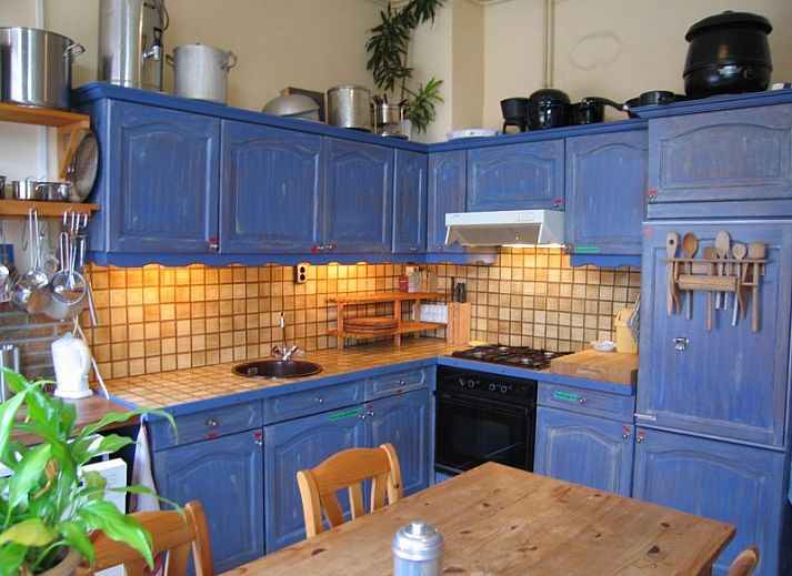 Eetruimte in Inn d'n Eenhoorn, Colijnsplaat, Noord-Beveland, met houten tafels en rustieke sfeer voor een gezellige maaltijd.