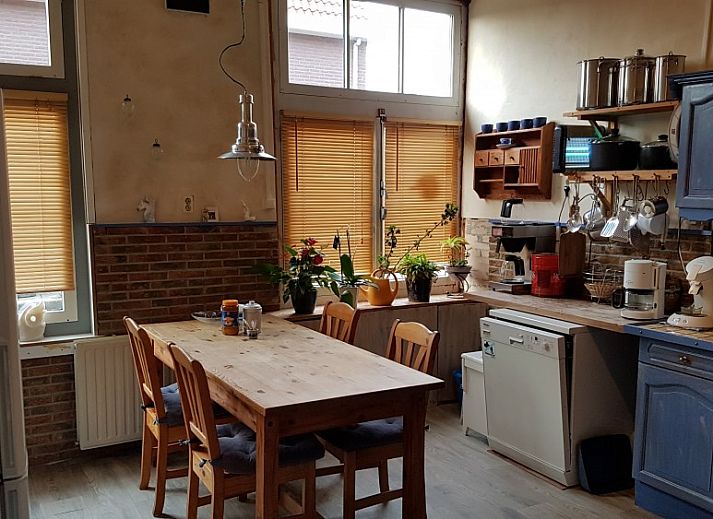 Eetruimte in Inn d'n Eenhoorn, Colijnsplaat, Noord-Beveland, met houten tafels en rustieke sfeer voor een gezellige maaltijd.