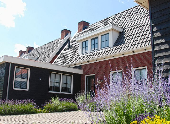 Exterior of Holiday Home Ganuenta in Colijnsplaat, North Beveland with colorful flowers and traditional architecture.