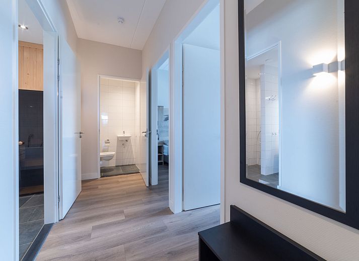 Charmanter Aussenbereich des Apartments Ganuenta in Colijnsplaat, Nord-Beveland, mit roten Ziegeln und bluehenden Blumen.