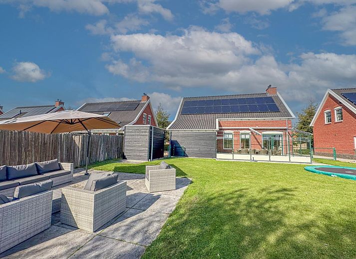 Ruim terras bij Dune Design 39 vakantiehuis in Colijnsplaat, Noord-Beveland, met comfortabele zithoek en groene tuin in zonnige omgeving.