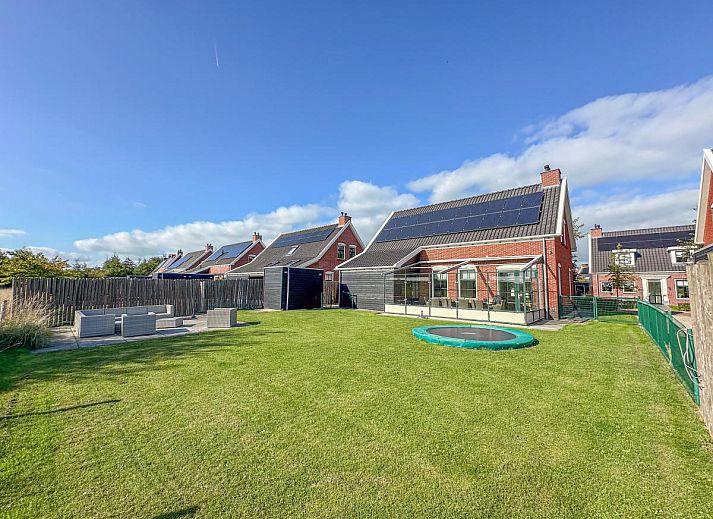 Ruim terras bij Dune Design 39 vakantiehuis in Colijnsplaat, Noord-Beveland, met comfortabele zithoek en groene tuin in zonnige omgeving.