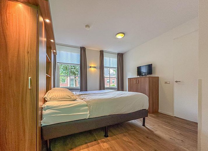 Ruim grasveld met trampoline bij vakantiehuis Dune Design 39 in Colijnsplaat, Noord-Beveland, Zeeland, omgeven door zonnige tuinen.