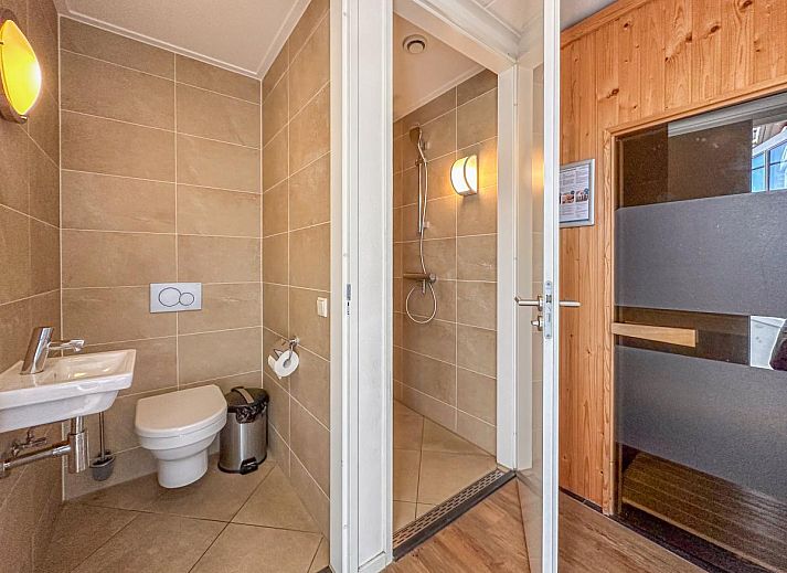 Ruime woonkamer van vakantiehuis Dune Design 39 in Colijnsplaat, Noord-Beveland, Zeeland met comfortabele zithoek en grote eettafel.