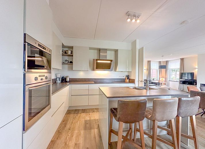 Overdekt terras van Coast Comfort in Colijnsplaat biedt een ontspannen eetruimte met uitzicht op de tuin, Noord-Beveland, Zeeland.