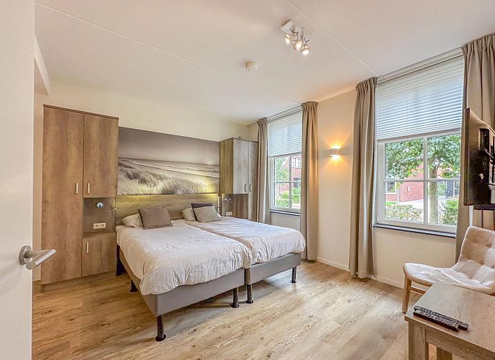 Gezellige woonkamer van Coast Comfort in Colijnsplaat met moderne inrichting en open haard, ideaal voor ontspanning, Zeeland.