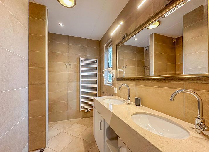 Gezellige woonkamer van Coast Comfort in Colijnsplaat met moderne inrichting en open haard, ideaal voor ontspanning, Zeeland.