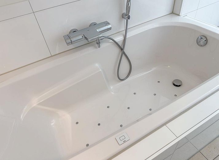 Stijlvolle woonkamer van Dune Deluxe 81, een vakantiehuis in Colijnsplaat, Noord-Beveland, Zeeland met moderne inrichting en veel natuurlijk licht.