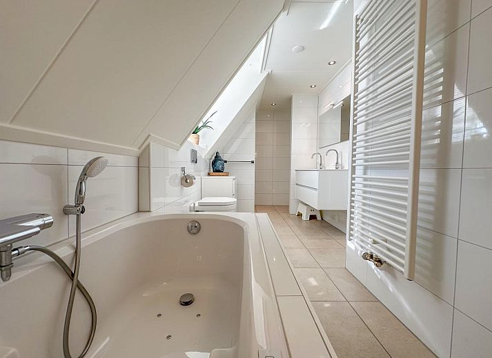 Stijlvolle woonkamer van Dune Deluxe 81, een vakantiehuis in Colijnsplaat, Noord-Beveland, Zeeland met moderne inrichting en veel natuurlijk licht.