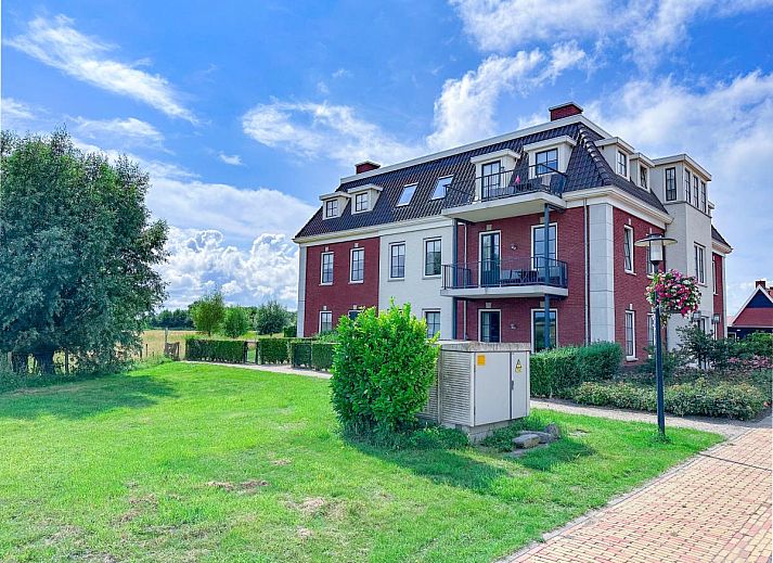Sauna Zee vacation home in Colijnsplaat, Zeeland with a charming facade and beautiful flower garden.