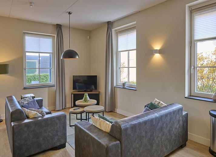 Sauna Zee vacation home in Colijnsplaat, Zeeland with a charming facade and beautiful flower garden.