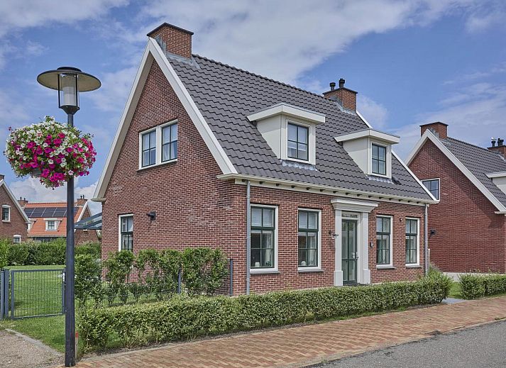 Ruim terras bij vakantiehuis Sea Deluxe in Colijnsplaat, Noord-Beveland, met uitzicht op groene tuin en moderne buitenmeubels.