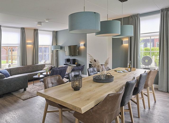 Charmante gevel van Sea Deluxe vakantiewoning in Colijnsplaat, Noord-Beveland, omgeven door bloeiende bloemen en rustige straat.