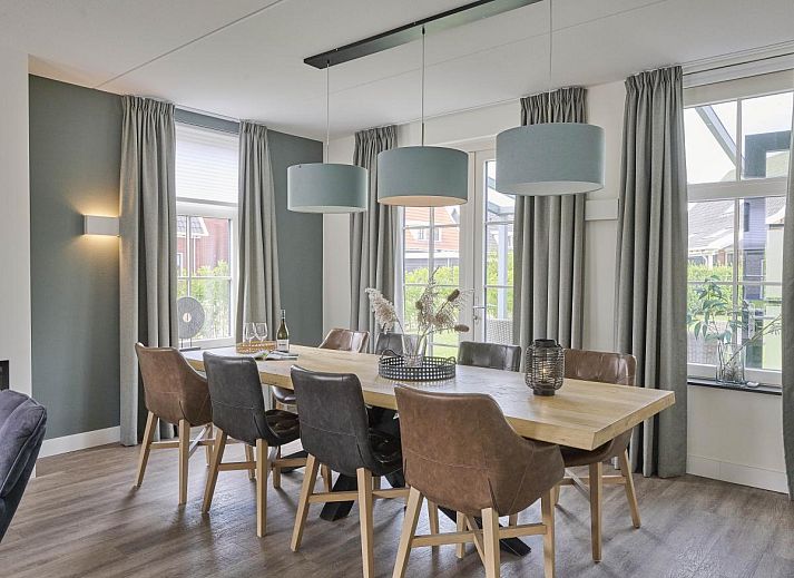 Charmante gevel van Sea Deluxe vakantiewoning in Colijnsplaat, Noord-Beveland, omgeven door bloeiende bloemen en rustige straat.