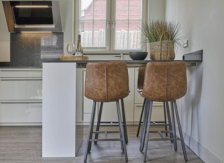 Charmante gevel van Sea Deluxe vakantiewoning in Colijnsplaat, Noord-Beveland, omgeven door bloeiende bloemen en rustige straat.