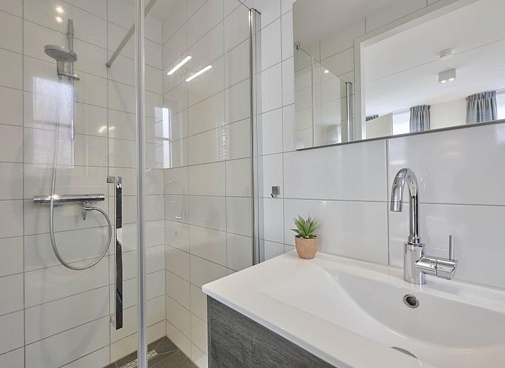 Stijlvolle eetkamer in Sea Deluxe vakantiewoning, Colijnsplaat, Noord-Beveland, met moderne stoelen en sfeervolle verlichting.