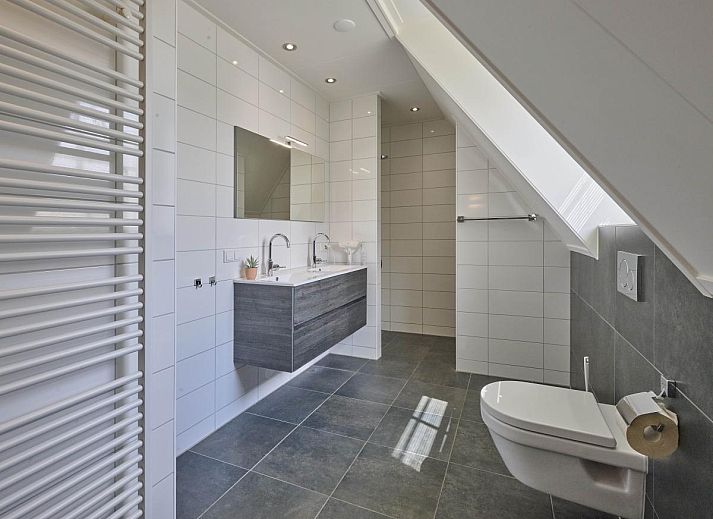 Stijlvolle eetkamer in Sea Deluxe vakantiewoning, Colijnsplaat, Noord-Beveland, met moderne stoelen en sfeervolle verlichting.