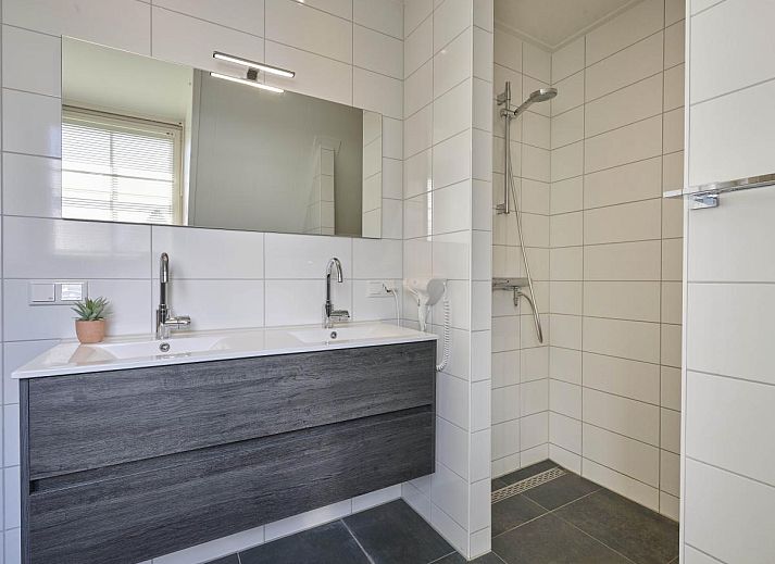 Detail van een knus kussen op de bank in Sea Deluxe vakantiehuis, Colijnsplaat, Noord-Beveland, voor een huiselijke sfeer.