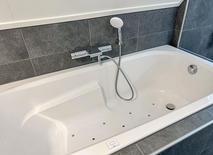 Gemuetliches Wohnzimmer im Ferienhaus Perfektion am Strand, Colijnsplaat, mit bequemer Sitzecke und Kamin.