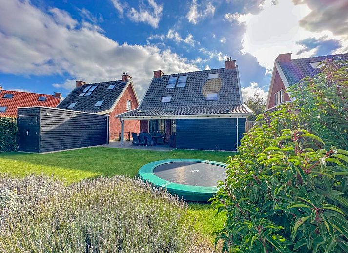 Stilvolles Wohnzimmer des Ferienhauses Perfektion am Strand in Colijnsplaat mit grossen Fenstern und modernen Moebeln.