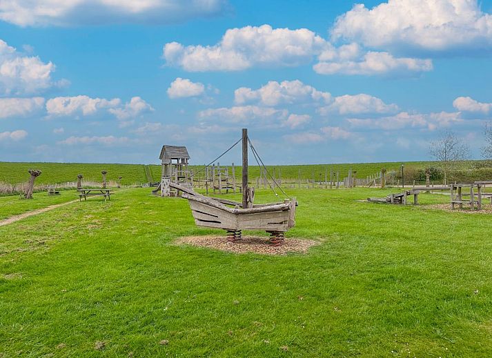 Ess- und Wohnbereich im Ferienhaus Perfektion am Strand, Colijnsplaat, mit grossem Tisch und stimmungsvoller Beleuchtung.
