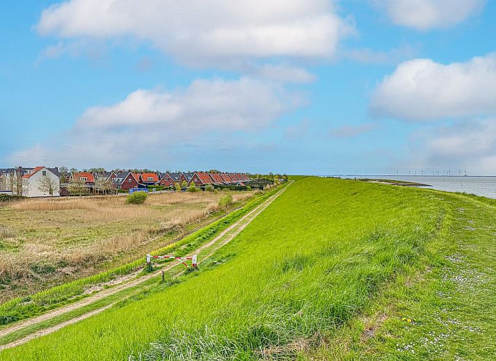 Ess- und Wohnbereich im Ferienhaus Perfektion am Strand, Colijnsplaat, mit grossem Tisch und stimmungsvoller Beleuchtung.