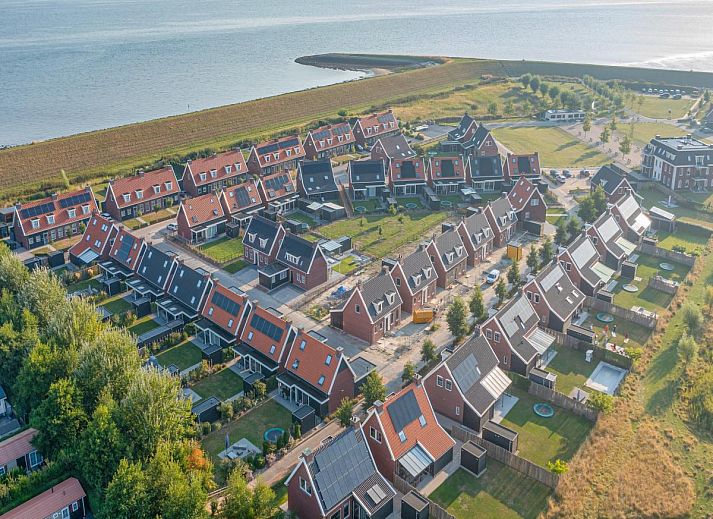 Ess- und Wohnbereich im Ferienhaus Perfektion am Strand, Colijnsplaat, mit grossem Tisch und stimmungsvoller Beleuchtung.