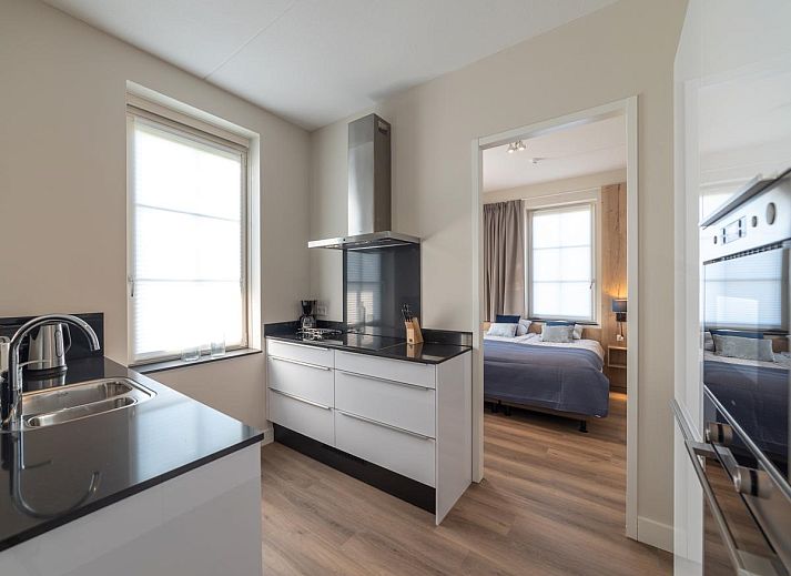 Charming entrance to SeaLuxe Residence vacation home in Colijnsplaat, North Beveland, surrounded by flowering plants.