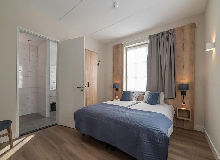 Charming entrance to SeaLuxe Residence vacation home in Colijnsplaat, North Beveland, surrounded by flowering plants.