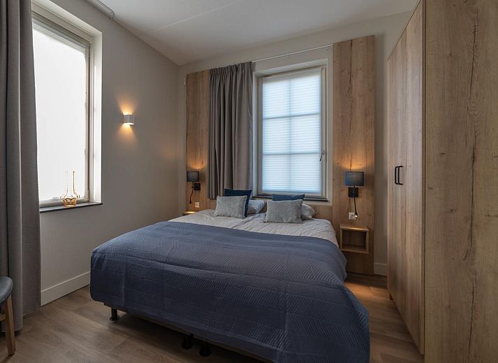 Charming entrance to SeaLuxe Residence vacation home in Colijnsplaat, North Beveland, surrounded by flowering plants.