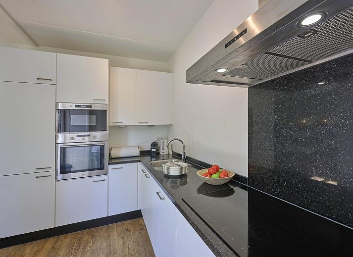 Gezellig terras bij Ocean Ease 49 in Colijnsplaat, Noord-Beveland, met ruime eettafel en parasol voor buitenmaaltijden.