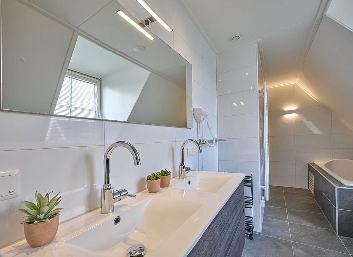 Ruime eetkamer in Ocean Ease 49, Colijnsplaat, Zeeland, met grote tafel en veel natuurlijk licht.