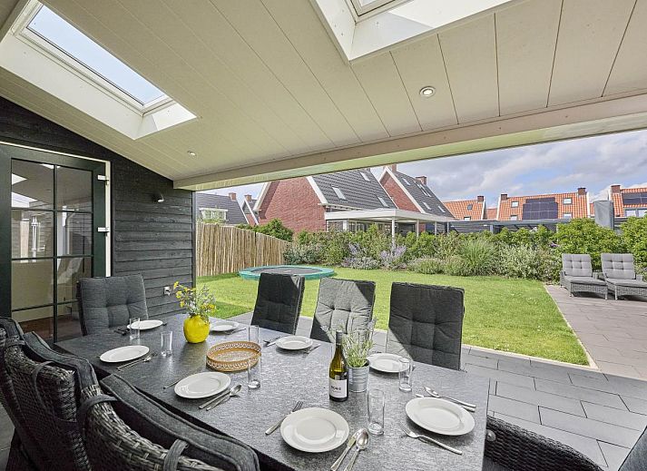 Beach deluxe vakantiehuis in Colijnsplaat, Zeeland met charmante bakstenen gevel en groene voortuin.