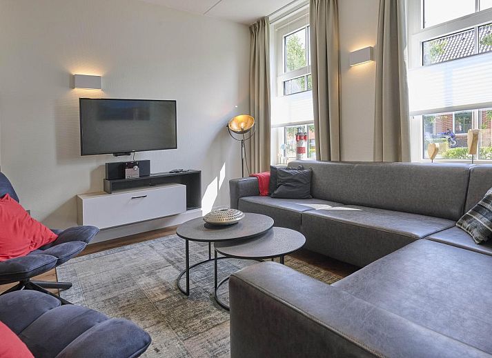 Beach deluxe vakantiehuis in Colijnsplaat, Zeeland met charmante bakstenen gevel en groene voortuin.