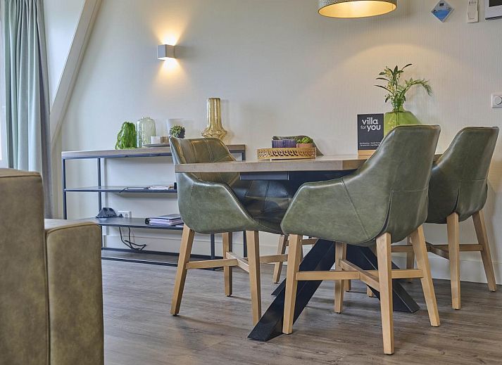 Cozy living room of Sauna Zee 27H in Colijnsplaat, North Beveland, with comfortable sofas and a modern fireplace.