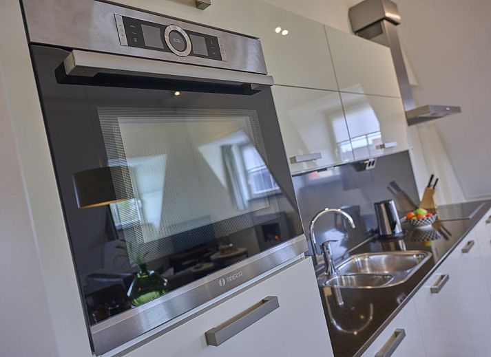 Cozy living room of Sauna Zee 27H in Colijnsplaat, North Beveland, with comfortable sofas and a modern fireplace.