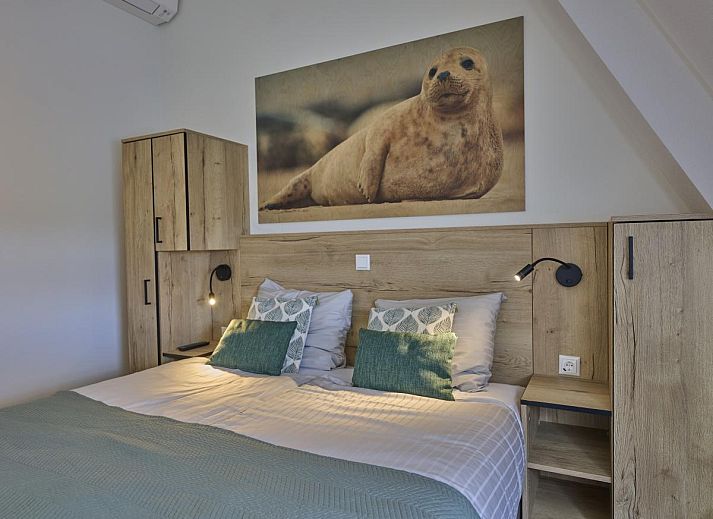 Cozy living room of Sauna Zee 27H vacation home in Colijnsplaat, North Beveland, with modern decor and lots of natural light.