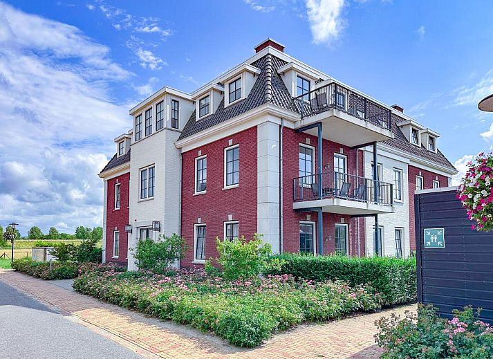 Cozy living room of Sauna Zee 27H in Colijnsplaat, North Beveland, with modern fireplace and flat-screen TV in the vacation home.