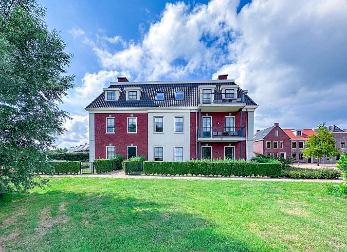 Cozy living room of Sauna Zee 27H in Colijnsplaat, North Beveland, with modern fireplace and flat-screen TV in the vacation home.
