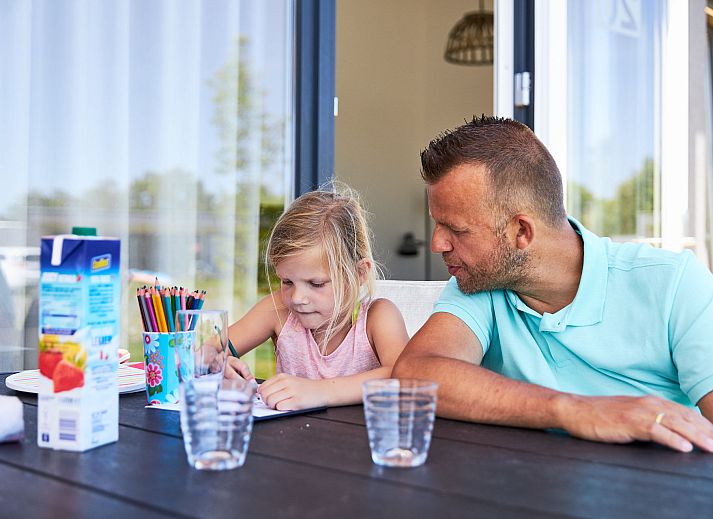 Essbereich im Bungalow the Dukdalf, Kamperland, mit Blick auf die Terrasse und die gruene Landschaft.