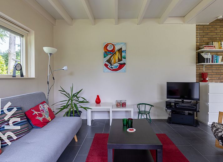 Blick in den Garten des Ferienhauses ZE167 in Kamperland, umgeben von Gruen und Blumen.