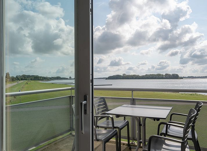 Appartement de Caisson in Kamperland met uitzicht op het groene grasveld en de nabijgelegen zee.