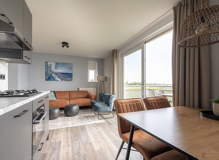 Appartement de Caisson in Kamperland met uitzicht op het groene grasveld en de nabijgelegen zee.